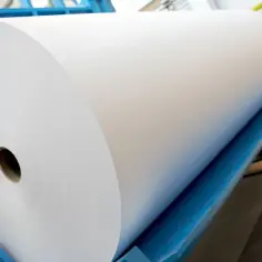 Ogromna rolka białego papieru, która pozwala wyobrazić sobie, jaką grubość ma kartka papieru.