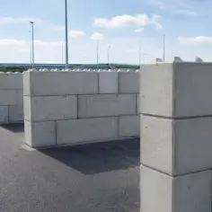 Betonowe bloki tworzące labirynt na tle nieba i drzew.