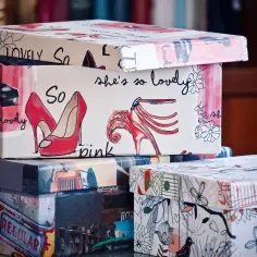 Stos ozdobnych pudełek z tektury kaszerowanej. Górne pudełko zdobią czerwone szpilki i napisy "So lovely", niższe mają motywy retro samochodów i ptaków.