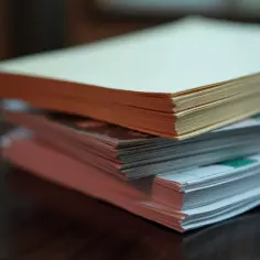 Stosy papieru o różnej gramaturze, jeden z nich ma pomarańczowe brzegi.