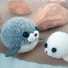 Urocze, puszyste foki z modeliny kawaii. Dwie słodkie figurki, szara i biała, zachęcają do zabawy i tworzenia własnych zwierzątek.