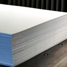 Gruba ryza papieru, z niebieską okładką, leży na metalowej powierzchni. Zastanawiasz się, ile waży ryza papieru?