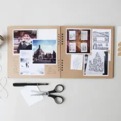 Otwarty album na zdjęcia, zdjęcia, rysunki, nożyczki i sznurek. To jest scrapbooking co to jest – tworzenie własnych, unikalnych pamiątek.